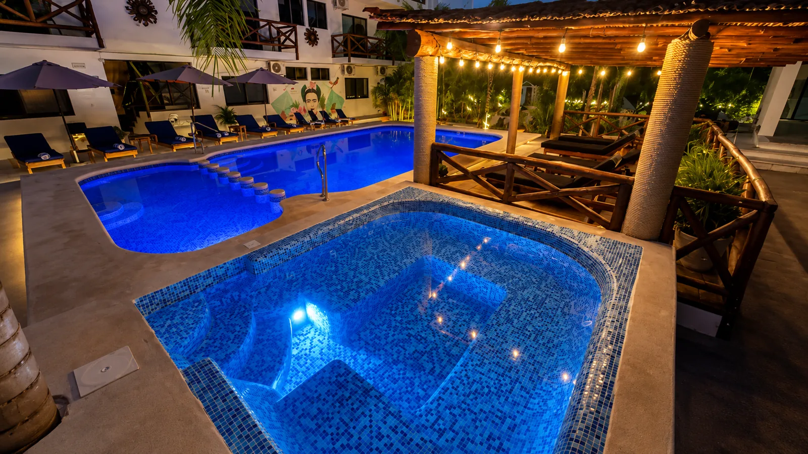 Alberca y jacuzzi iluminados por la noche