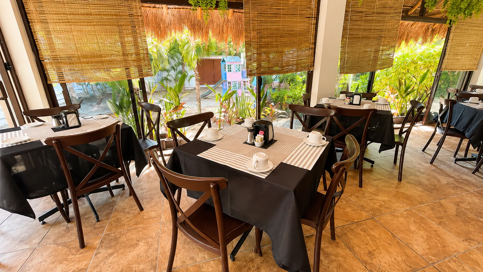 Mesas y ambiente tropical del restaurante Villas Palmar